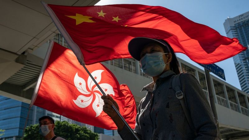 亲北京团体成员在香港立法会综合大楼外挥舞中国国旗与香港特区区旗